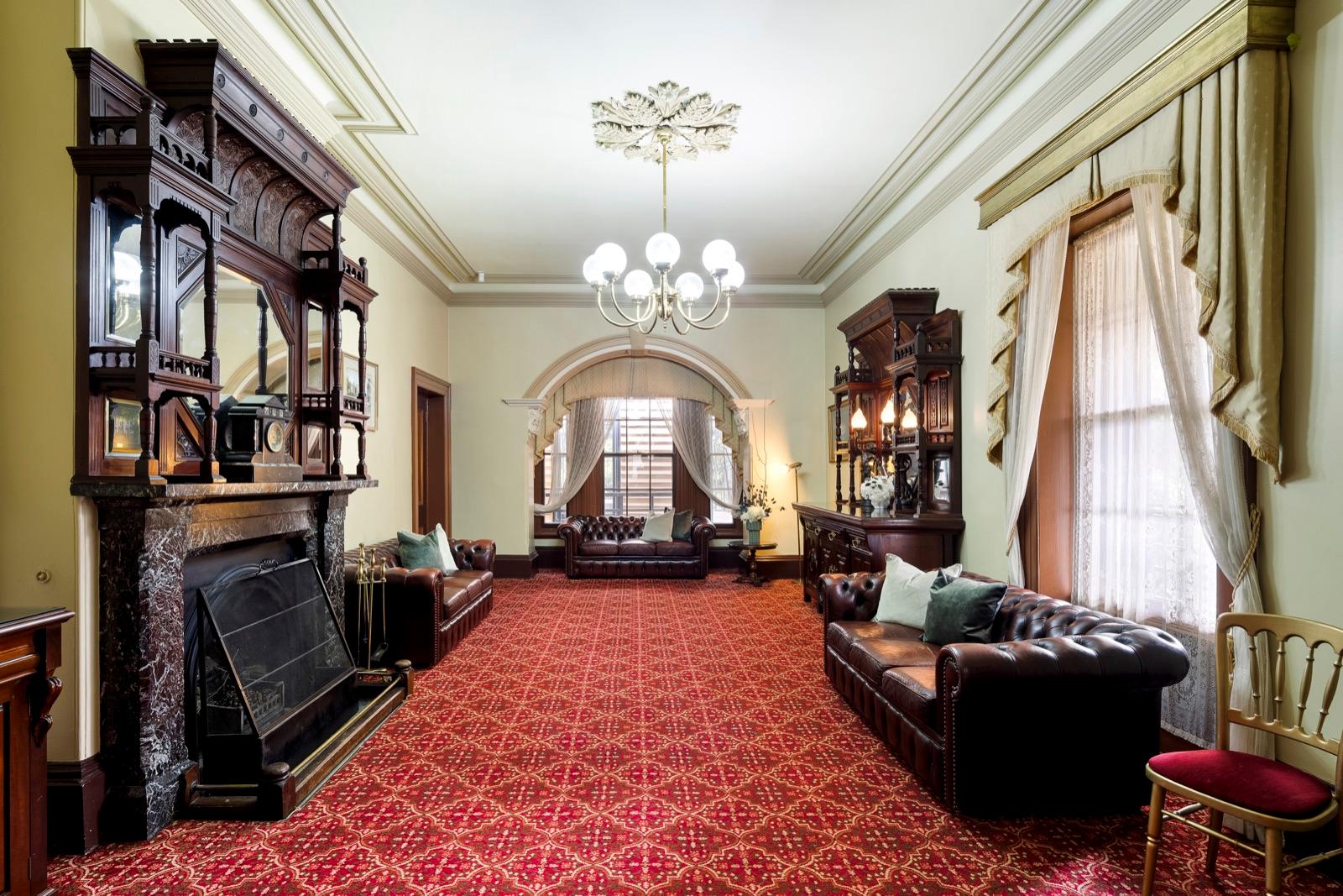 Grand drawing room with carved fireplace and chandelier
